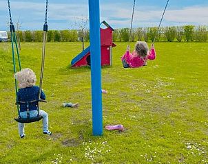 Kindvriendelijke speelplaats bij vakantiehuisje in Borssele, Zuid-Beveland, met schommels en veel ruimte om te spelen.