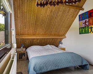 Slaapkamer met kleurrijke kunst in Vakantiehuis Haus Anni, Hansweert, Zuid-Beveland, ideaal voor rust.