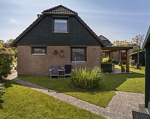 Charmante buitenkant van Vakantiehuis Haus Anni in Hansweert, Zuid-Beveland, met groene tuin.