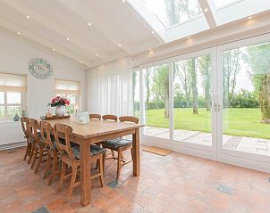 Eetkamer met uitzicht op tuin in Vakantiehuisje in Hansweert, Zuid-Beveland, Zeeland.