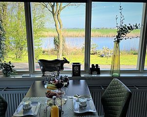 Ontbijt met uitzicht op de rivier in Huisje in Brandwijk, Brandwijk, Zuid-Holland.