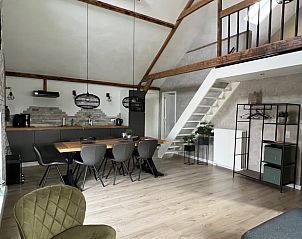 Open leefruimte in vakantiehuis Streefkerk, met eetgedeelte en trap naar bovenverdieping.