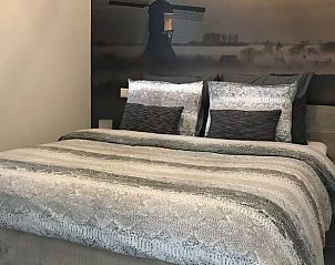 Slaapkamer met windmolen schilderij in Vakantiehuisje in Streefkerk, rustgevend en sfeervol.