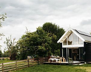 Vakantiehuisje in Langerak met terras en weelderige bomen in Alblasserwaard, Zuid-Holland.