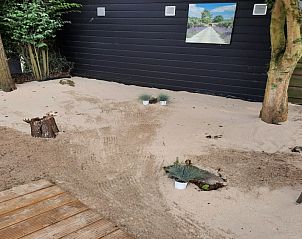 Rustige zandtuin bij Chalet Sunrise in Ouddorp, Zeeland, ideaal voor ontspanning in een natuurlijke setting.