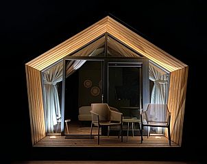 Illuminated veranda of Huisje in Sommeldsijk, a cozy vacation home in Sommelsdijk, Goeree-Overflakkee for evening relaxation.