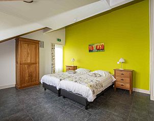 Slaapkamer met zithoek in ZH018 vakantiehuis Gouda, met houten accenten en uitzicht op de natuur.