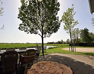 Uitzicht vanaf het terras van De Schuur vakantiehuis in Kaag, Groene Hart, Zuid-Holland met groene velden.