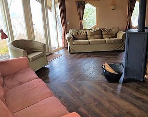 Comfortabele zithoek in Vakantiehuis Reeuwijk, met uitzicht op de natuurlijke omgeving.