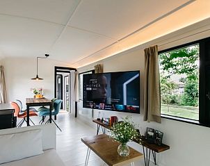 Moderne binnenruimte van Vakantiehuisje in Woerdense Verlaat met comfortabele zithoek en tuinzicht, Zuid-Holland.