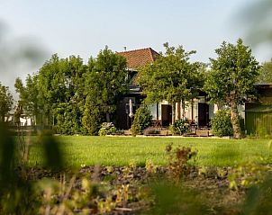 Huisje in Hazerswoude-Dorp, vakantiehuis omringd door groen in het Groene Hart, Zuid-Holland, met een uitnodigend terras.