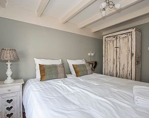 Stijlvolle slaapkamer in Vakantiehuis in Aarlanderveen met rustieke kast.