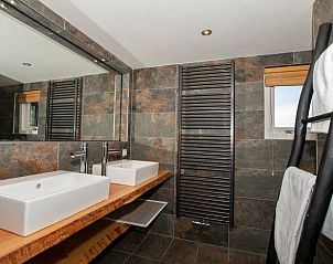 Luxe badkamer in Vakantiehuis in Aarlanderveen met moderne wastafel en spiegel.