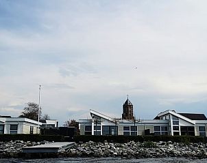 Buitenzijde van Huisje in Rijnsaterwoude vakantieaccommodatie in Groene Hart Zuid-Holland met kerk op achtergrond.
