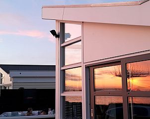 Reflectie van zonsondergang op raam van Huisje in Rijnsaterwoude vakantieaccommodatie in Groene Hart Zuid-Holland.