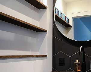 Stijlvolle badkamer in Huisje in Rijnsaterwoude vakantieaccommodatie in Groene Hart Zuid-Holland met ronde spiegel.