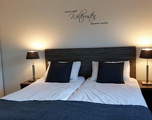 Sfeervolle slaapkamer in vakantiehuis Duinparel 126, Noordwijk, met modern interieur en warme verlichting.