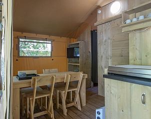 Gezellige binnenruimte van Safaritent 4 in Kijkduin, perfect vakantiehuis aan de Noordzeekust met houten interieur en eetgedeelte.