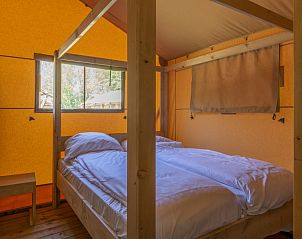 Ruime slaapkamer met tweepersoonsbed in Safaritent 4, Kijkduin. Geniet van een ontspannen verblijf aan de Noordzeekust in Zuid-Holland.