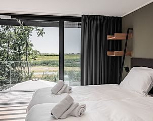 Slaapkamer in Sunset 6 vakantiehuis, Zwartewaal, met uitzicht op groene velden in Voorne Putten, Zuid-Holland.