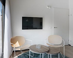 Moderne zithoek in vakantiehuis Meadow 4M, Zwartewaal, Voorne Putten. Comfortabele stoelen, tv en natuurlijk licht creren een ontspannen sfeer.
