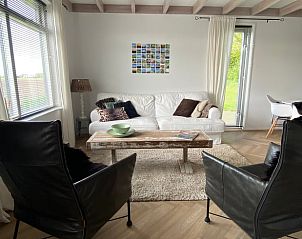 Ruime woonkamer in Vakantiehuis in Klaaswaal, met comfortabele stoelen en landelijke charme.