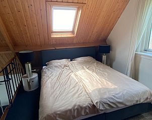 Knusse slaapkamer onder houten dak in Vakantiehuis in Klaaswaal, een charmant verblijf in Zuid-Holland.