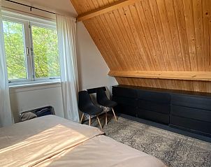 Slaapkamer met houten interieur in Vakantiehuis in Klaaswaal, een rustgevende vakantiewoning in Hoekse waard.