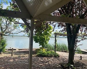 Rustieke veranda van Vakantiehuisje in Bleiswijk met uitzicht op het meer in Rotterdam eo, Zuid-Holland.